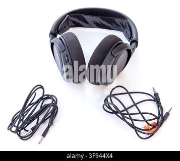 Black overear headphones and two audio cables are on a white background Stock Photo