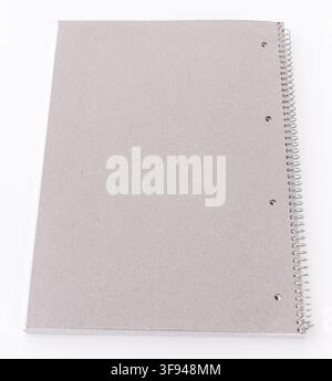 A plain grey spiral notebook rests on a clean white background Stock Photo