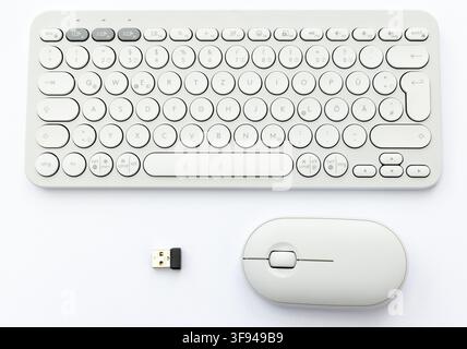 A white wireless keyboard, mouse, and USB dongle on white Stock Photo