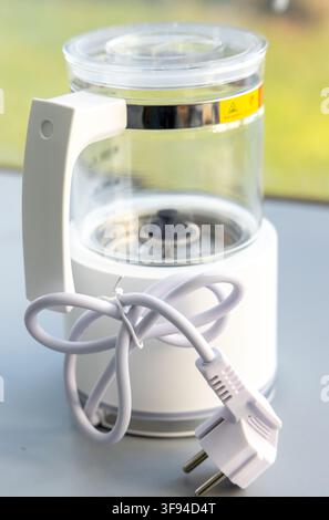 A small white electric kettle with a transparent glass body Stock Photo