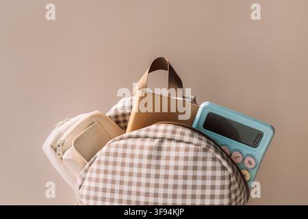 School backpack with notebook and blue calculator, stylish back to school background Stock Photo