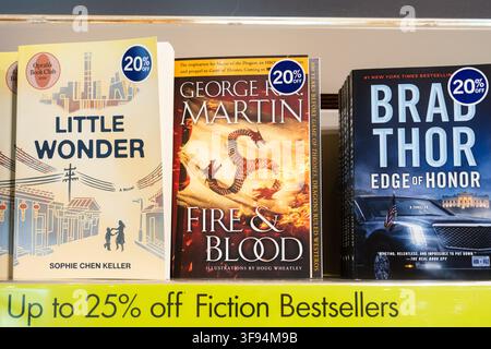 Toronto, Canada - June 18, 2026: Bookstore display of fiction bestsellers on shelf with colorful hardcovers, discount stickers, and promotional sign Stock Photo