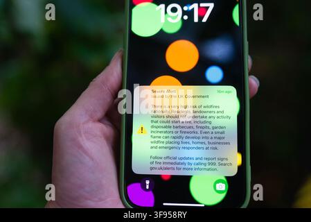 UK Government Emergency Alert warning of a very high national wildfire risk displayed on a smartphone during the August 2026 UK heatwave. Stock Photo