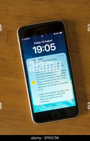 14 August 2026.  A Severe Alert issued by the UK Government displayed on an iPhone.  Warns of very high risk of wildfires nationally and cautions people not to carry out any activity that could cause a fire. Stock Photo