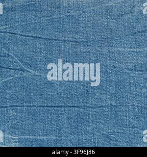 Blue denim fabric texture with visible weave and slight folds. Durable cotton textile material surface close up. Fashion background for apparel design Stock Photo