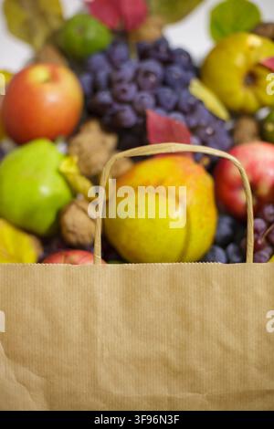 A vertical close up shot of a blank brown craft paper bag with large copy space for text or branding logo set against a soft blurred background of fre Stock Photo