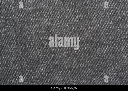 Black denim fabric texture background. Detailed closeup of dark jeans textile pattern. Woven cotton material for clothing design, fashion apparel indu Stock Photo