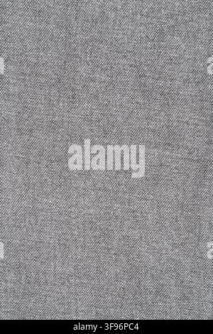 Grey denim fabric texture with visible diagonal weave. Close up view of washed cotton material for clothing design. Durable textile pattern background Stock Photo
