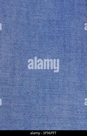 Blue denim jeans fabric texture background. Close up of raw cotton textile material. Natural rough material surface for clothing design and fashion in Stock Photo