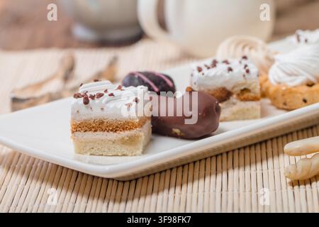 Small cakes with different stuffing on white plate Stock Photo
