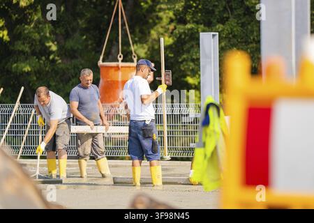 Construction workers compact concrete on a construction site surrounded by safety barriers, parking garage construction, Calw, Germany Stock Photo