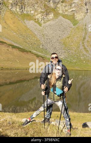 Couple of first time hikers having fun and posing for photo at a lake in Rila Mountain, Bulgaria Stock Photo