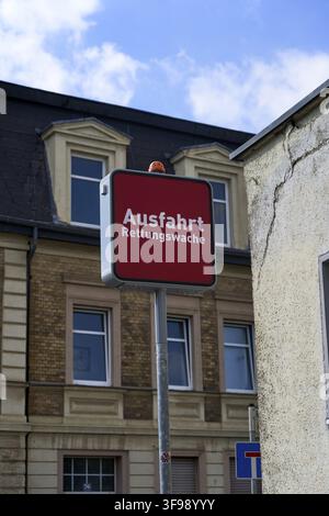 Exit to the emergency medical services station, emergency medical services on call, sign with a red background in front of an older building against a Stock Photo
