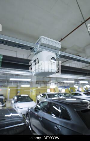 Security camera mounted on a rail above parked cars in a parking garage, Milaneo, Stuttgart, Germany Stock Photo