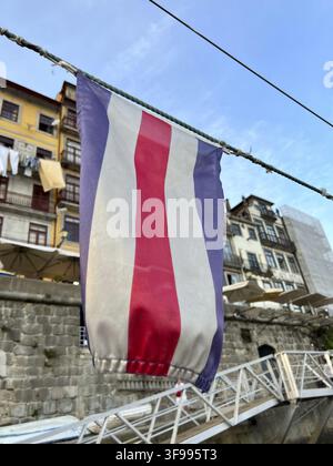 A flag is hanging on a wire. The flag is red, white, and blue Stock Photo