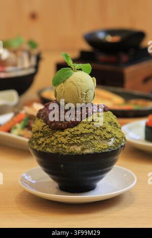 Japanese matcha green tea shaved ice dessert topped with red beans and a scoop of ice cream. Stock Photo