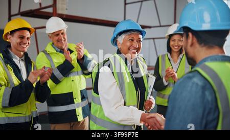 Engineer, builder and handshake on site with clapping, well done and approval of property renovation. Happy, people and shaking hands in building with Stock Photo