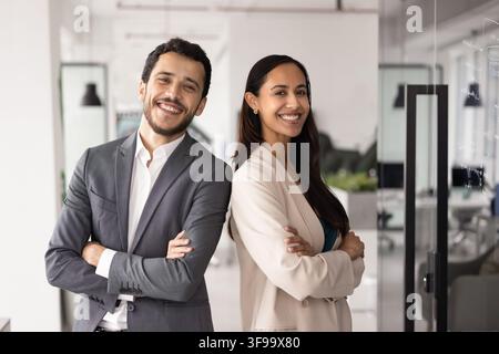 Portrait of smiling multiethnic team members posing in corporate office Stock Photo