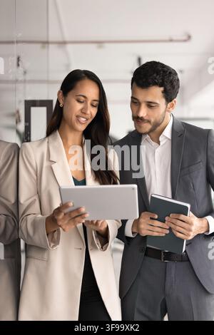 Two multiethnic team members reviewing new application on tablet Stock Photo
