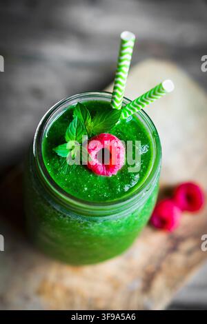 A green smoothie garnished with a raspberry Stock Photo