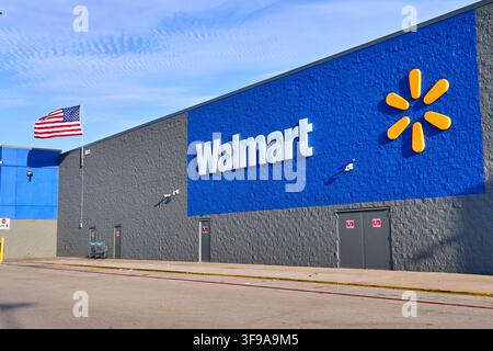 DALLAS, TX, USA - JULY 30, 2026: The exterior of a Walmart store prominently displays its logo on the blue wall, alongside the American flag waving. W Stock Photo
