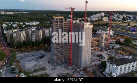 Aerial view of Keppel Data Center Reit construction site with two high-rise buildings, red cranes, and surrounding urban infrastructure during golden Stock Photo