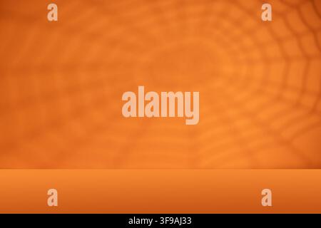 Orange Halloween background with spiderweb shadow and empty tabletop for spooky product mockup party poster or seasonal display Stock Photo