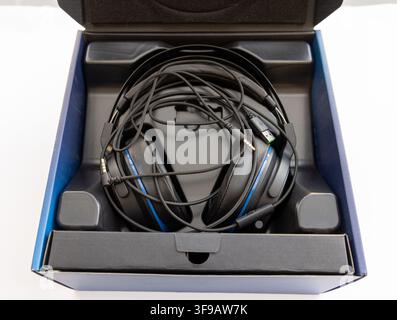 Black and blue headphones are neatly packed in their opened retail box Stock Photo
