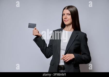 Businesswoman holding blank credit card isolated on grey background Stock Photo