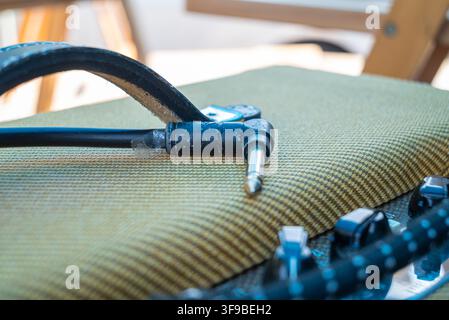 Electric guitar plug cable resting on audio amplifier equipment The Concept of analog sound and musician lifestyle Stock Photo