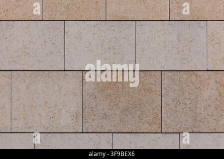 Full-frame texture of beige travertine stone cladding tiles in a staggered brick pattern Stock Photo
