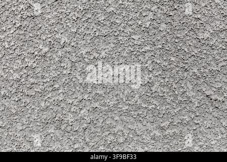Full-frame close-up of rough grey plaster wall texture, monochrome architectural background Stock Photo