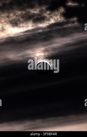 View of a solar eclipse partially obscured by dark, dramatic clouds in the sky over Lancaster, England, United Kingdom. Stock Photo