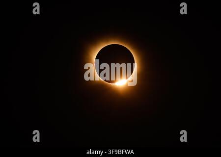 Spain - 12 August 2026: View of a total solar eclipse with the sun's corona visible and a bright flare of light emerging from behind the moon. Stock Photo