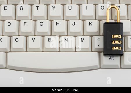 Combination lock on a white computer keyboard for data protection and cybersecurity Stock Photo