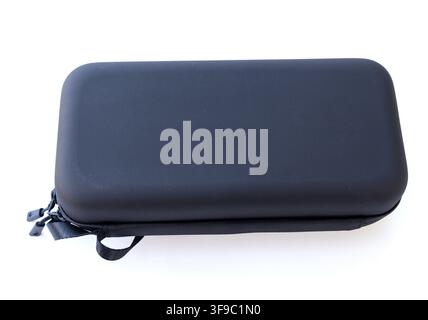 A rectangular black hard case with a zipper rests on a white background Stock Photo