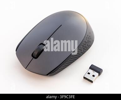 A wireless computer mouse and USB receiver are on a white background Stock Photo