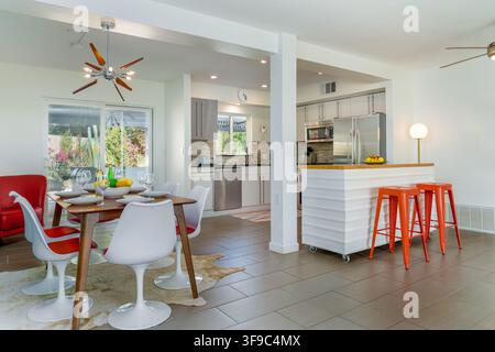 A bright and airy Mid-Century Modern Dining Room and Kitchen Open Floor Plan. Stock Photo