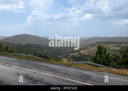 Winding mountain road passing through green valleys Stock Photo