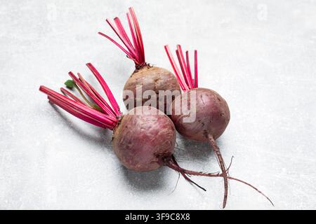 Whole young beets on gray textured table, closeup Stock Photo