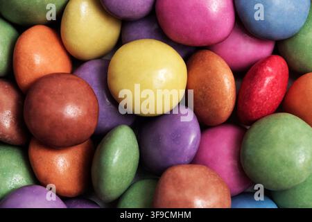 Full frame macro texture of colorful sugar-coated chocolate candies in bright rainbow shades, sweet food background Stock Photo