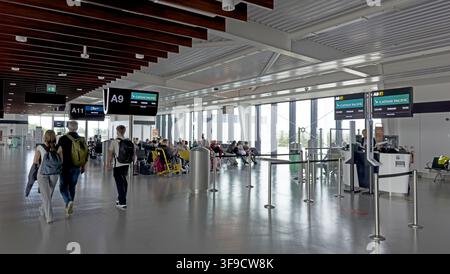Passengers inside the modern spacious Terminal 2 departures area at Manchester Airport, England, UK, during a busy bank holiday travel period. Stock Photo