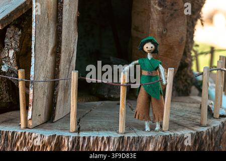 Eco friendly children toy made of string and wood standing behind a small twig fence Stock Photo