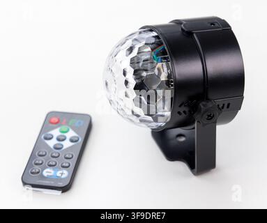 A black LED disco ball light and its remote control on white Stock Photo