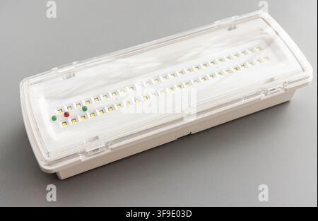 A white LED emergency light with indicator lights rests on gray Stock Photo