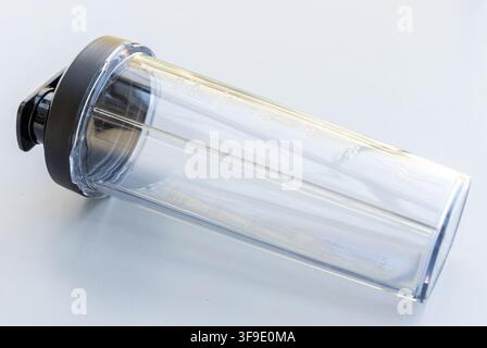 An empty clear protein shaker bottle with a black lid is on white Stock Photo