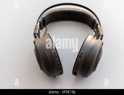 Modern black overear headphones with visible controls on white Stock Photo