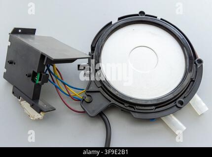 Electronic components with wires and a circular membrane lie on a grey background Stock Photo