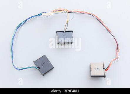 Colorful wires connect small electronic modules and a white connector Stock Photo