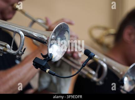 Close-up of a trumpet bell with a clip-on microphone during a live performance. Stock Photo